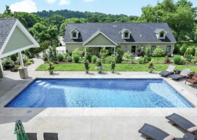 Large inground fiberglass rectangular pool with steps on one end and sitting area on other