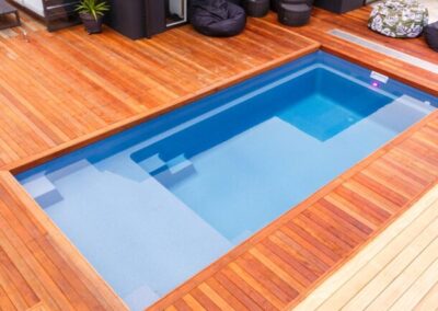 Different levels fiberglass pool with wood deck surround