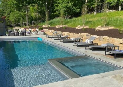 Rectangular inground pool with different depths, sitting areas and attached spa