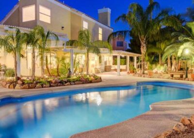 Large curved edge fiberglass pool lit up at night
