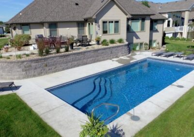 Rectangular inground fiberglass pool with wavy steps into pool